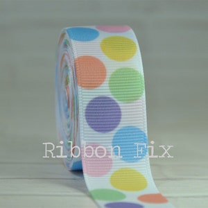 May include: White ribbon with colorful polka dots. The dots are in shades of blue, green, yellow, orange, and purple.
