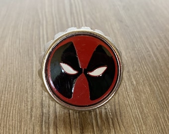 May include: A silver bottle opener with a red and black Deadpool mask design.