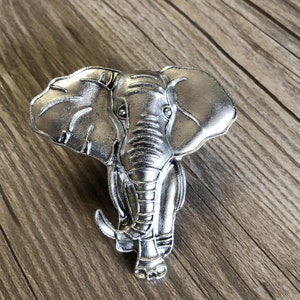 May include: A silver elephant figurine with detailed features, including textured skin and a trunk.