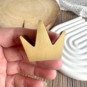 Può includere: Una tazza di ceramica bianca con manico nero e la scritta "But First, Coffee" in nero, in grassetto. La tazza è su una superficie bianca.