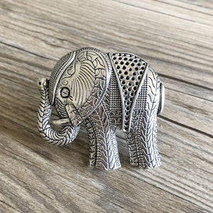 Peut inclure: Une figurine d'éléphant en argent avec des détails complexes et une surface texturée.