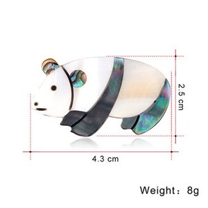 Puede incluir: Un broche de panda blanco y negro hecho de n&aacute;car iridiscente. El broche mide 4,3 cm de ancho y 2,5 cm de alto y pesa 8 gramos.