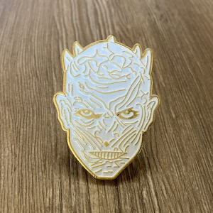 Puede incluir: Pin de esmalte blanco con contorno dorado que representa la cara del Rey de la Noche de Juego de Tronos.