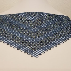 May include: A blue and green beaded lace shawl with a diamond pattern. The shawl has a scalloped edge.