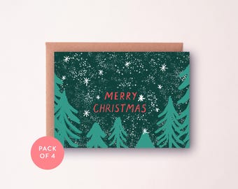 Può includere: Un biglietto di Natale con sfondo verde scuro con fiocchi di neve bianchi e pini verdi stilizzati. Le parole "MERRY CHRISTMAS" sono in rosso. Il biglietto è all'interno di una busta marrone, con un cerchio rosa che dice "PACK OF 4".