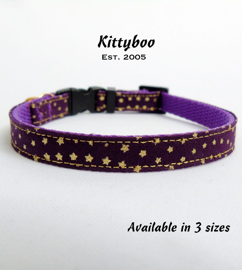 Puede incluir: Collar de gato morado con estrellas doradas. El collar est&aacute; hecho de tela y tiene una hebilla de pl&aacute;stico. El texto "Kittyboo Est. 2005" est&aacute; impreso en el collar. El texto "Disponible en 3 tama&ntilde;os" est&aacute; impreso debajo del collar.