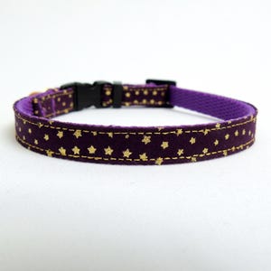 Puede incluir: Collar para mascotas morado con estampado de estrellas doradas. El collar tiene una hebilla de pl&aacute;stico negra.