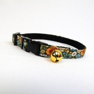 May include: A floral patterned cat collar with a black buckle and a gold bell.