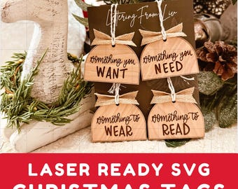 Könnte beinhalten: Vier hölzerne Weihnachtsgeschenkanhänger mit rustikalem braunen Finish. Die Anhänger sind in Form eines abgerundeten Rechtecks ​​geformt und haben oben ein Loch für eine Schnur. Die Anhänger sind mit dem Text "something you want", "something you need", "something to wear" und "something to read" verziert.