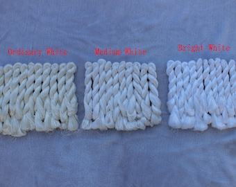 May include: Three rectangular swatches of twisted white yarn arranged side by side. The left swatch is labeled Ordinary White, the center is labeled Medium White, and the right swatch is labeled Bright White, showing distinct shades of white.