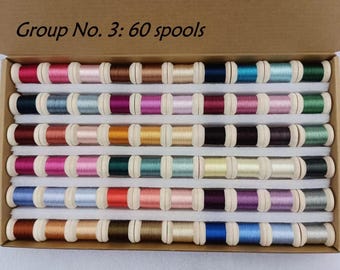 May include: A box containing 60 spools of thread in various colors. The spools are arranged in rows, with colors ranging from pinks and reds to blues and greens. The text "Group No. 3: 60 spools" is visible on the box.