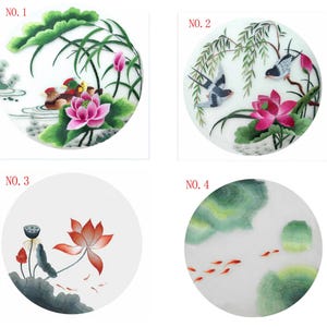 Puede incluir: Cuatro diseños redondos bordados sobre tela blanca. Los diseños presentan una variedad de motivos florales y animales, incluyendo flores de loto, pájaros y peces. Los diseños están numerados del 1 al 4.