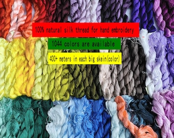 Op de afbeelding: Een verzameling strengen zijden borduurgaren in een breed kleurenspectrum, waaronder rood, geel, groen, blauw, paars en bruin. De tekst op de afbeelding luidt: 100% natural silk thread for hand embroidery, 1044 colors are available, 400+ meters in each big skein(color).