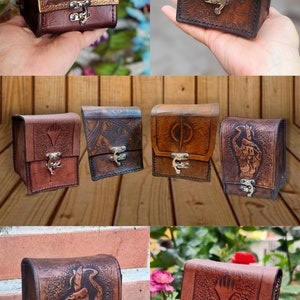 May include: A collection of six leather card cases with various designs. The cases are brown and have a flap with a metal clasp. The designs include a floral pattern, a symbol, a hand, and a symbol with a diamond shape.