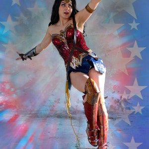 Op de afbeelding: Een vrouw verkleed als Wonder Woman poseert in een dramatische houding. Ze draagt een rood, blauw en gouden kostuum tegen een sterrenhemel.