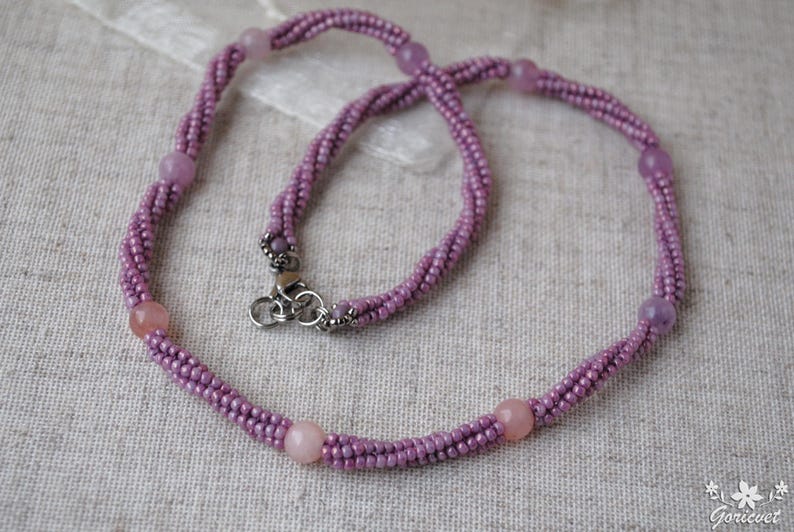 Puede incluir: Un delicado collar de cuentas moradas con un cierre plateado y peque&ntilde;as piedras redondas moradas.