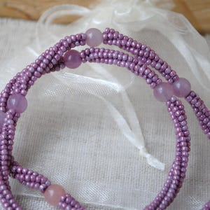 Puede incluir: Un collar de doble cadena hecho de peque&ntilde;as cuentas moradas y cuentas m&aacute;s grandes de color morado y rosa.