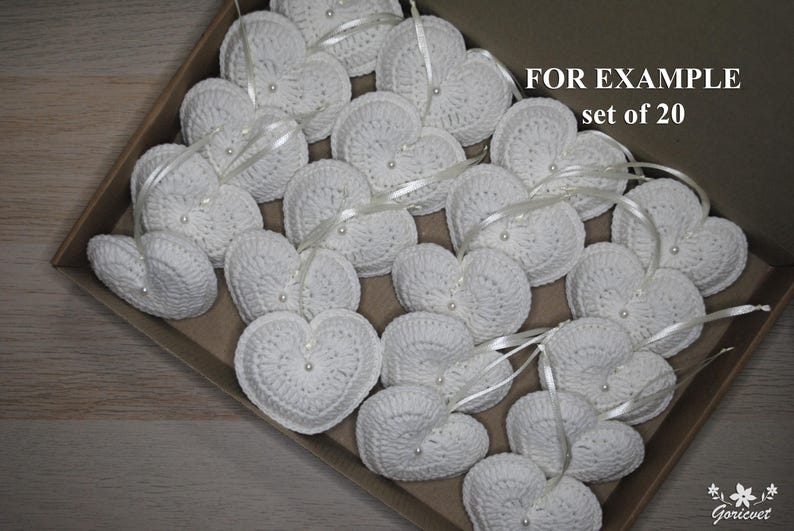 May include: A set of 20 white crocheted hearts with pearl beads and satin ribbon. FOR EXAMPLE set of 20.