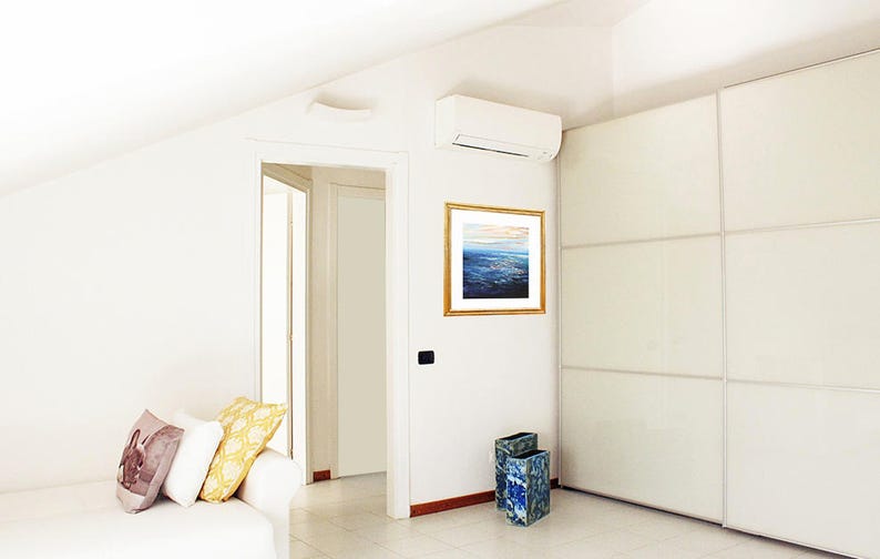 May include: A white room with a white couch, a white door, a white closet, and a white air conditioner. There is a framed painting of a seascape on the wall. There are two blue and green decorative vases on the floor.