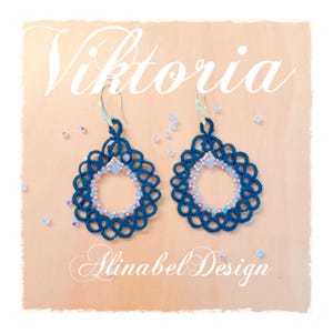 May include: A pair of dark blue earrings with a delicate lace design and pink beads. The earrings are called "Viktoria" and are by "Alinabe Design".