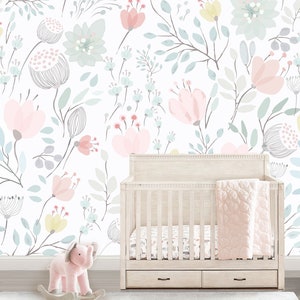 May include: A white crib with a pink and white floral patterned wallpaper behind it. The crib has a white mattress and a pink blanket. There is a pink rocking elephant in the foreground.