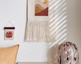 Woven wall hanging with sunrise landscape