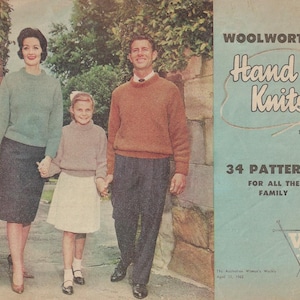 May include: A vintage magazine cover featuring a family of three. The magazine is titled "Woolworths Hand Knits" and has the text "1962, No. 2" and "34 Patterns for all the family". The cover features a woman in a blue sweater and black skirt, a man in a brown sweater and black pants, and a girl in a white dress and a brown sweater. The magazine cover is on a blue background.