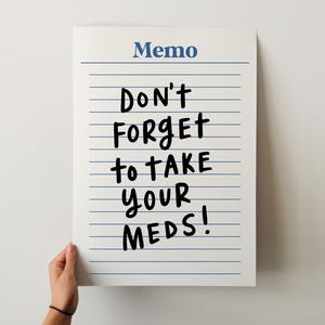 Könnte beinhalten: Ein weißer, rechteckiger Notizblock mit blauen horizontalen Linien. Das Wort Memo ist oben in Blau gedruckt. Der Text Don't forget to take your meds! ist in großen, fetten, schwarzen, handschriftlichen Buchstaben in der Mitte der Seite zu sehen.
