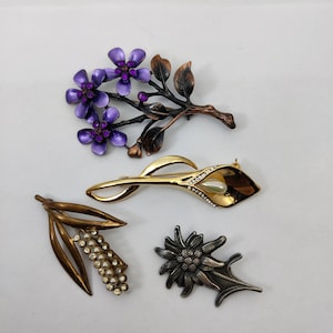 vintage brooches depicting richly decorated flowers and plants