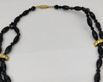 signed BALENCIAGA PARIS vintage necklace with 2 rows and pendant, in gold metal, enamel, rhinestones and black crystal beads signed BALENCIAGA PARIS vintage necklace with 2 rows and pendant, in gold metal, enamel, rhinestones and black crystal beads