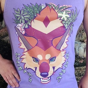 May include: Purple tank top with a graphic of a red fox with green plants around its head. The fox has a white diamond on its forehead and a white stripe down its nose.
