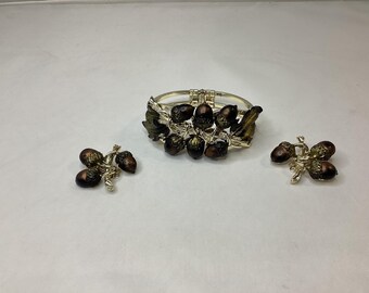 Vintage gold tone clamper bracelet featuring a cluster of dimensional, acorns and oak leaves.
