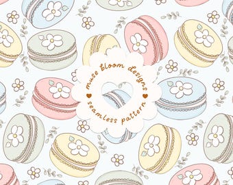 May include: A seamless pattern featuring pastel-colored macarons in shades of pink, blue, yellow, and mint green, each decorated with a white flower. The design includes small sprigs and text that reads muse bloom designs seamless pattern.