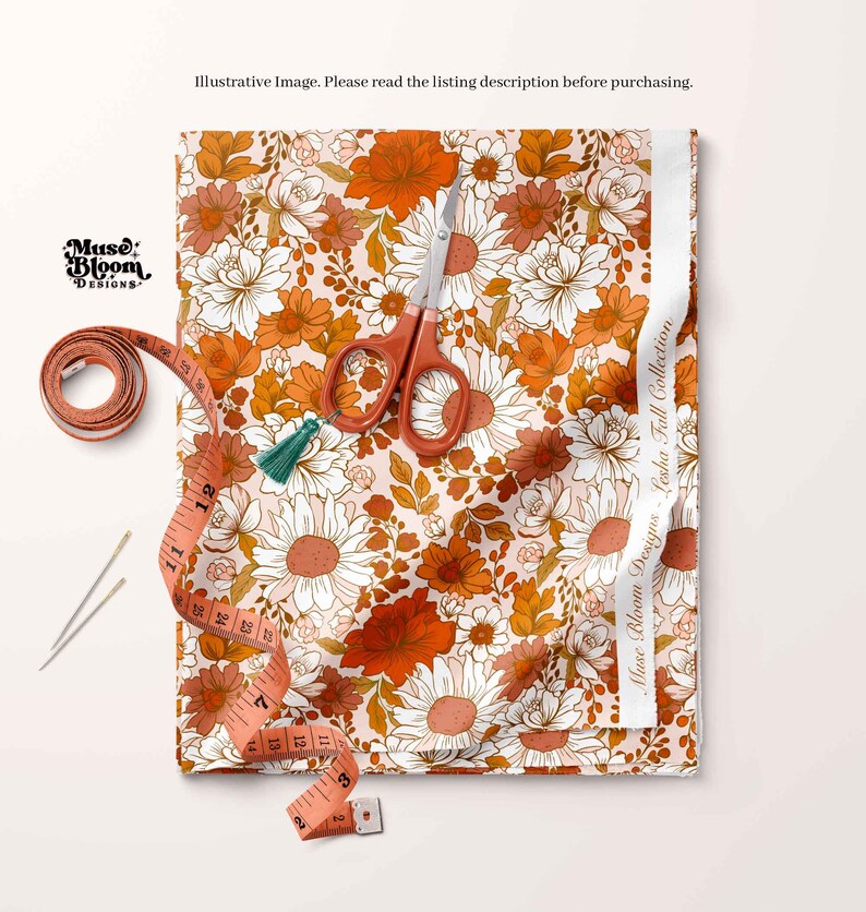 May include: A close-up of a fabric with a floral pattern in shades of orange, white, and brown. The fabric is laid out on a white surface with a measuring tape, scissors, and two sewing needles.