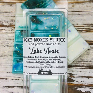 K&ouml;nnte beinhalten: Ein Set mit sechs Wachsschmelzen in einem durchsichtigen Plastikbeh&auml;lter. Die Wachsschmelzen sind hellblau und gr&uuml;n mit Glitzer. Das Etikett lautet "FOXY MOXIE STUDIO Handgegossene Wachsschmelzen Lake House Duftnoten: K&uuml;hle Wasser, Aromatische Gr&uuml;ne, Lavendel, Veilchen, Schwarzer Pfeffer, Sandelholz, Patchouli, Amber, Moschus 1.75 oz/50(g) www.etsy.com/shop/FoxyMoxieStudio"