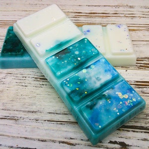 K&ouml;nnte beinhalten: Ein blauer und wei&szlig;er Wachsschmelzer mit glitzerndem Finish. Der Wachsschmelzer ist in sechs Quadrate unterteilt.