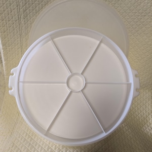 May include: White plastic round serving tray with a lid. The tray has six sections for serving different foods.