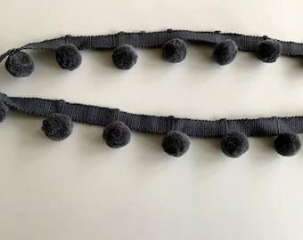 May include: Gray pom-pom trim with a dark gray ribbon base. The trim has a row of pom-poms on each side.