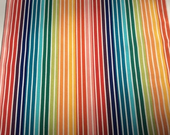 May include: A colorful fabric with vertical stripes in various shades of red, orange, yellow, green, blue, and purple. The stripes are evenly spaced and alternate with white stripes.