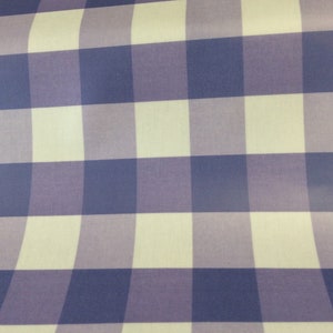 May include: A white and purple checkered fabric with a subtle sheen. The fabric has a large gingham pattern.