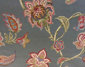 Peut inclure: Un tissu gris avec un motif floral composé de fleurs roses, rouges, bleues et dorées. Les fleurs sont stylisées et ont un design de type paisley.