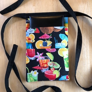 May include: Black fabric waist bag with a black leather pocket and a colorful tropical cocktail print. The bag has a long black strap.