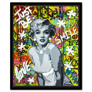 May include: A colorful and abstract painting of Marilyn Monroe with a yellow background. The painting features graffiti-style text including "Just Be", "Love", and "Smile".