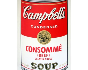May include: A Campbell's Condensed Consommé (Beef) Soup can. The can has a red top with the Campbell's logo and the word "CONDENSED". The bottom half is white with the soup name and a gold seal.