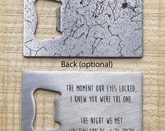 May include: A silver metal bottle opener with a constellation design on the front and a personalized message on the back. The message reads "THE MOMENT OUR EYES LOCKED, I KNEW YOU WERE THE ONE. THE NIGHT WE MET WASHINGTON DC, 6.26.2020"