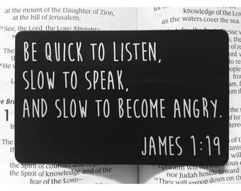 May include: Black rectangular sign with white text that reads "Be quick to listen, slow to speak, and slow to become angry. James 1:19".