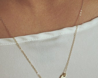 May include: A gold necklace with a V-shaped pendant that says "Lindsay" on it.