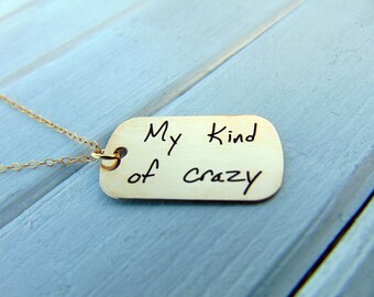 May include: Gold necklace with a silver tag that says "My kind of crazy".