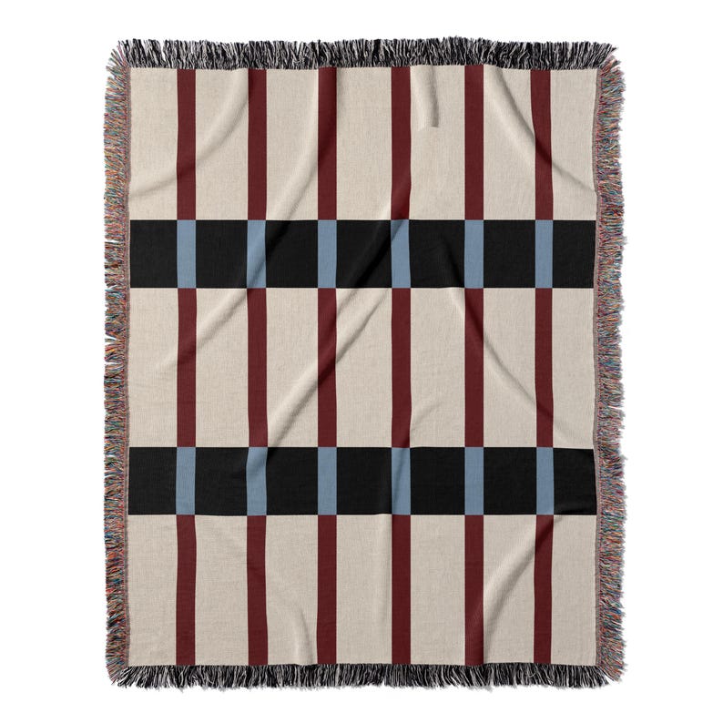 May include: A woven throw blanket with a geometric pattern. The design features alternating vertical stripes of burgundy and cream, intersected by black and light blue squares. The edges are finished with a fringe.