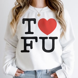 May include: White sweatshirt with the text "I ♥ FU" in black block letters and a red heart. The sweatshirt is a casual style, suitable for everyday wear. The design is simple and bold.